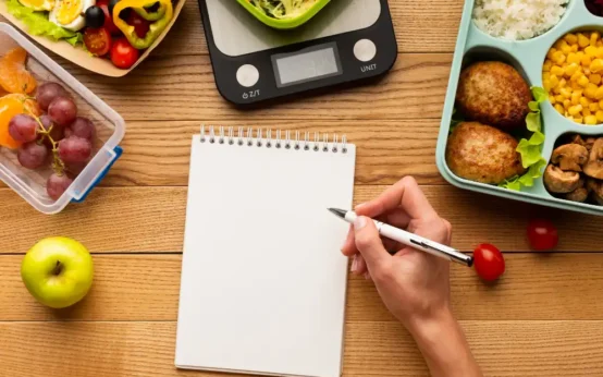 Planejamento semanal de refeições com lista, alimentos saudáveis, balança digital e marmitas para economizar tempo e dinheiro na cozinha.