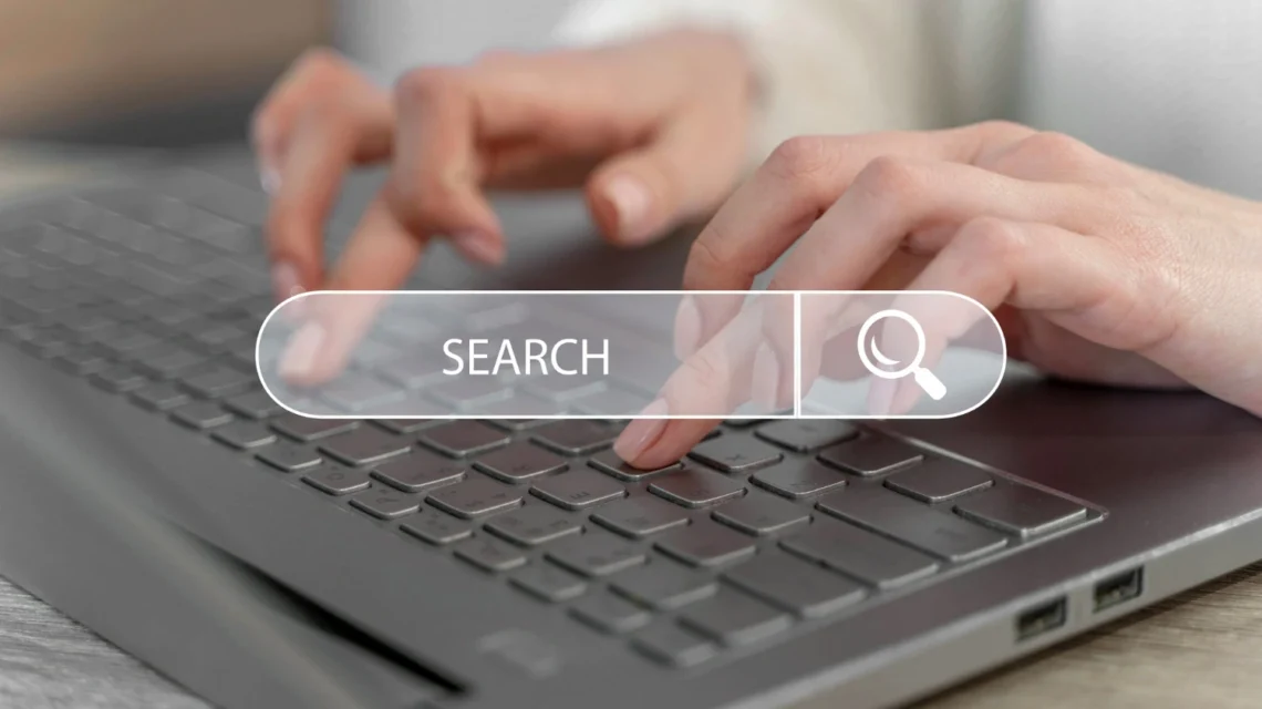 Pessoa utilizando um laptop com uma busca digital destacada sobre 'Como empresas industriais podem aparecer melhor no Google' em um ambiente de escritório.