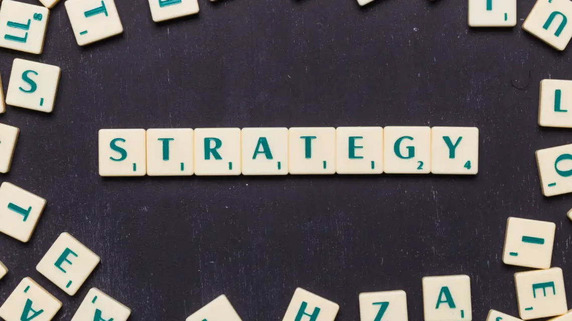 Imagem de peças de dominó formando a palavra 'STRATEGY' com o foco em estratégias de uso de palavras-chave no setor industrial.