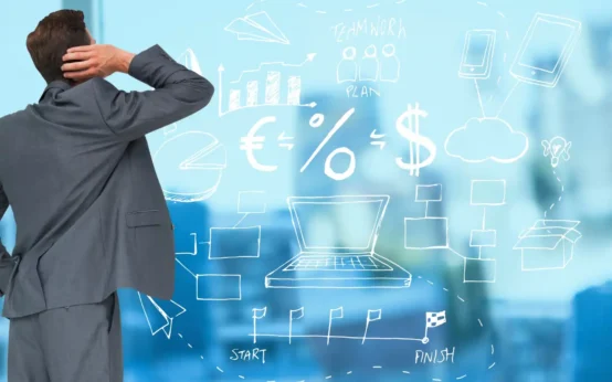 Homem de terno analisando indicadores econômicos e gráficos de crescimento em quadro digital, essencial para empresários que precisam acompanhar dados econômicos atuais.